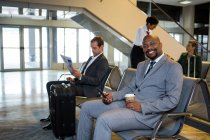 Ritratto di uomo d'affari che utilizza il cellulare nell'area d'attesa del terminal dell'aeroporto — Foto stock