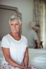 Preoccupata e premurosa donna anziana seduta nella camera da letto — Foto stock