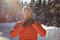 Mann zieht im Winter warme Kleidung im Wald aus — Stockfoto