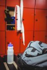 Close-up of water bottle and bag in locker room — Stock Photo