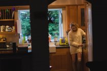 Femme préparant le café dans la cuisine à la maison — Photo de stock