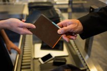 Personal femenino del aeropuerto que entrega tarjetas de embarque al pasajero en la terminal del aeropuerto - foto de stock