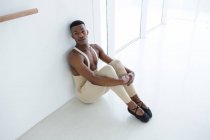 Nachdenklicher Ballerino sitzt auf dem Boden im Ballettstudio — Stockfoto