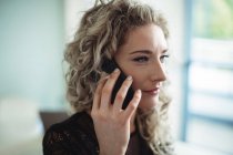 Крупный план деловой женщины, разговаривающей по мобильному телефону в офисе — стоковое фото