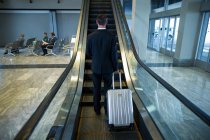 Задній вид бізнесмена на ескалатора в аеропорту — стокове фото
