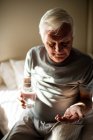 Uomo anziano che prende la medicina in camera da letto a casa — Foto stock