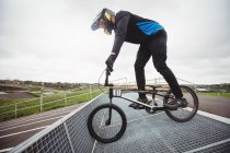 Ciclista se preparando para BMX corrida na rampa de partida no parque de skate — Fotografia de Stock