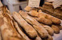 Різні види хліба, складені разом на лічильнику хлібобулочних виробів в супермаркеті — стокове фото