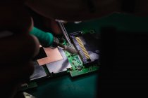 Nahaufnahme von Mann lötet Chip auf Handy in Reparaturzentrum — Stockfoto