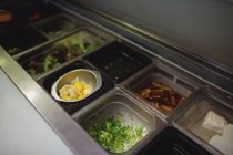 Las bandejas de las hortalizas distintas picadas en la cocina del restaurante - foto de stock