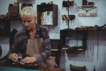 Craftswoman working on a piece of leather in workshop — Stock Photo