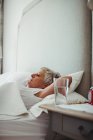 Donna anziana che dorme sul letto in camera da letto a casa — Foto stock