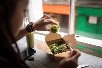 Frau gießt im Café grüne Soße auf Salat — Stockfoto