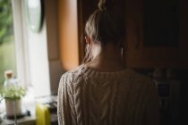 Вид спереду вдумливої жінки на кухні вдома — стокове фото