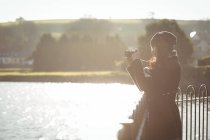 Жінка фотографує цифрову камеру в сонячний день у парку — стокове фото
