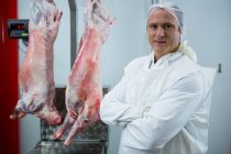 Retrato de açougueiro de pé com os braços cruzados na fábrica de carne — Fotografia de Stock