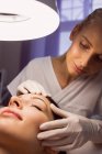 Dermatologe untersucht weibliche Patientenhaut in Klinik — Stockfoto
