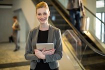 Porträt einer Geschäftsfrau mit digitalem Tablet am Flughafen — Stockfoto