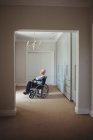 Homem idoso sentado em cadeira de rodas em casa — Fotografia de Stock
