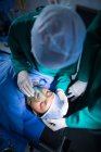 Cirurgiões ajustando máscara de oxigênio no paciente no teatro de operação do hospital — Fotografia de Stock