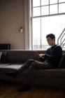 Человек, использующий цифровой планшет в гостиной на дому — стоковое фото