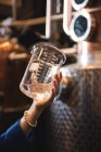 Крупним планом жінка тримає мірний стакан на заводі пива — стокове фото