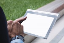 Abgeschnittenes Bild von Geschäftsmann mit digitalem Tablet vor Bürogebäude — Stockfoto