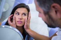 Arzt überprüft Haut des Patienten nach kosmetischer Behandlung in Klinik — Stockfoto