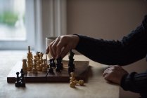 A meio da secção do homem a jogar xadrez em casa — Fotografia de Stock