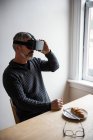 Homem usando fones de ouvido de realidade virtual em casa — Fotografia de Stock