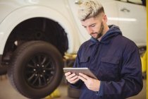 Mechaniker mit digitalem Tablet in Werkstatt — Stockfoto