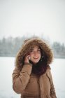 Mulher sorridente em casaco de pele falando no celular durante o inverno — Fotografia de Stock