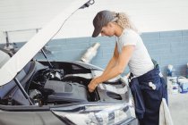 Femme mécanicien entretien voiture au garage de réparation — Photo de stock