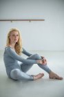 Портрет балерины, отдыхающей на полу в балетной студии — стоковое фото
