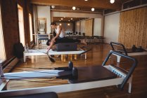 Trainer hilft einer Frau beim Pilates-Training im Fitnessstudio — Stockfoto