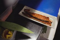 Gebratener Fisch auf Serviertablett in der Küche — Stockfoto