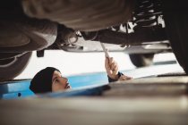 Mechanic fixing a car at repair garage — Stock Photo