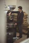 Man operating coffee roasting machine in coffee shop — Stock Photo