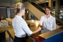 Mitarbeiterinnen geben am Check-in-Schalter im Flughafenterminal die Bordkarte aus — Stockfoto