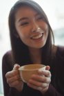 Усміхнена жінка має чашку кави в кафе — стокове фото