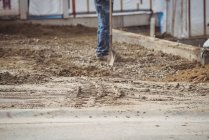 Sezione bassa del lavoratore edile livellamento fango in cantiere — Foto stock