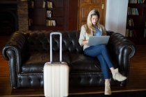 Mulher bonita usando laptop na área de espera no terminal do aeroporto — Fotografia de Stock