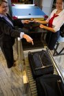 Empresária apontando para a bagagem mantida na correia transportadora no terminal do aeroporto — Fotografia de Stock