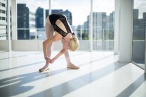 Ballerine attachant ses chaussures de ballet dans le studio — Photo de stock