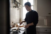 Чоловік готує їжу на кухні вдома — стокове фото