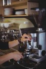 Cameriera che tiene portafilter riempito con caffè macinato in caffè — Foto stock