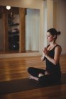 Donna che si rilassa praticando yoga in palestra — Foto stock