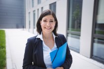 Портрет уверенной предпринимательницы, стоящей снаружи офисного здания — стоковое фото