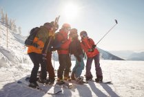 Группа лыжников делает селфи на мобильном телефоне зимой — стоковое фото