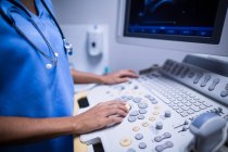Enfermera usando dispositivo ultrasónico en el hospital - foto de stock